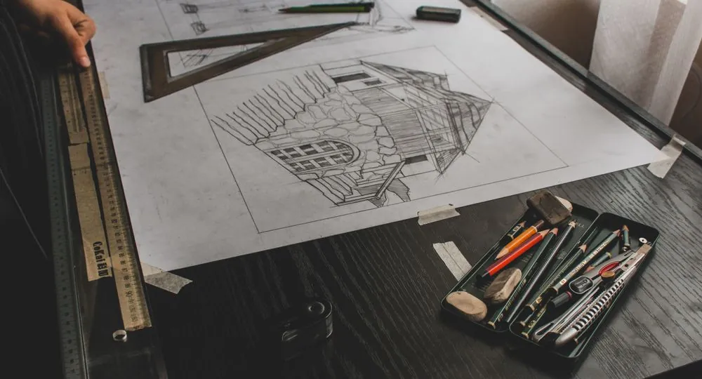 A hand-drawn garden plan on a desk with pencils and a ruler
