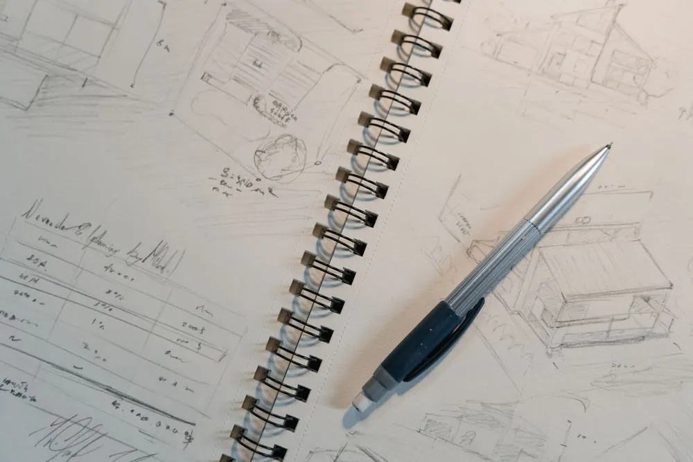 A spiral-bound sketchbook of plant drawings with a pencil